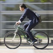 Businessman riding bike, side view