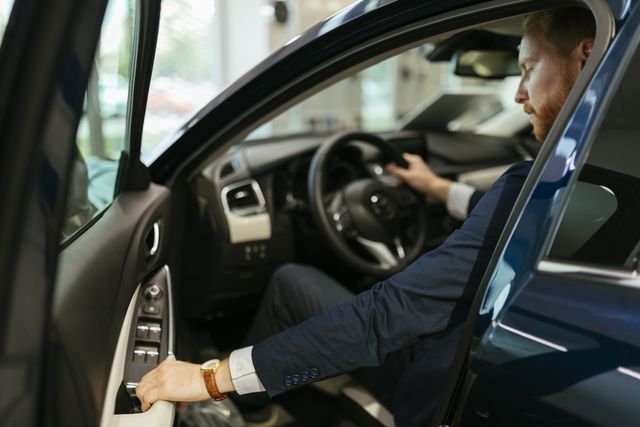 businessman tests automobile in automobile dealership