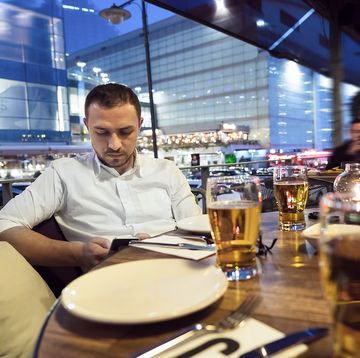businessman using mobile phone and drinking beer in restaurant