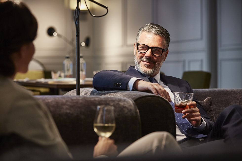 Businessman with a drink sitting in hotel