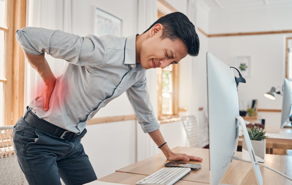 businessman with back pain, muscle injury and burnout at office desk young frustrated man suffering from spinal inflammation, body discomfort or strain and healthcare stress emergency