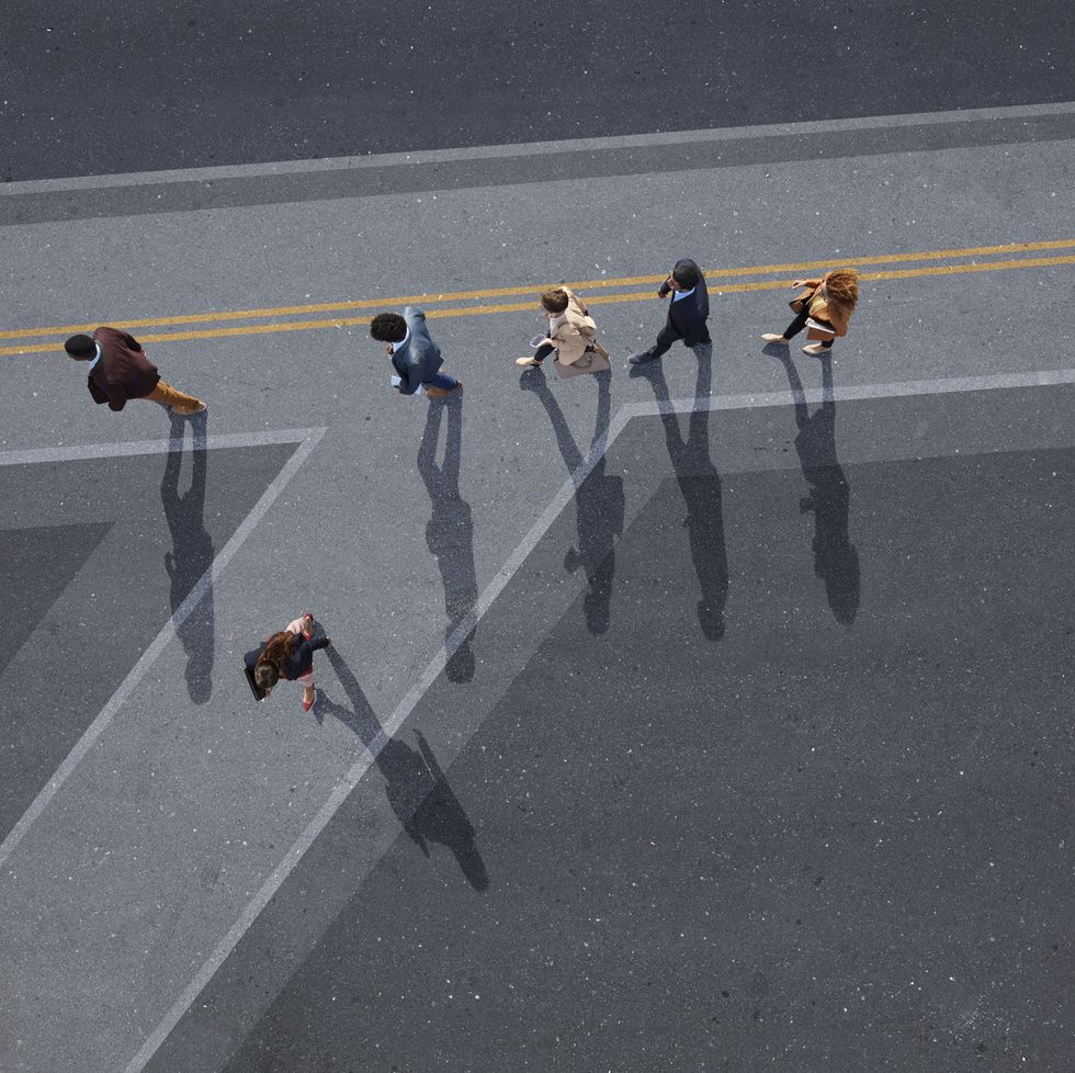 businesspeople walking in line on road, painted on asphalt, one person walking off in different direction