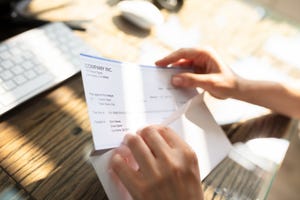 businessperson opening envelope with paycheck