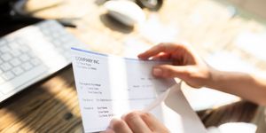 businessperson opening envelope with paycheck