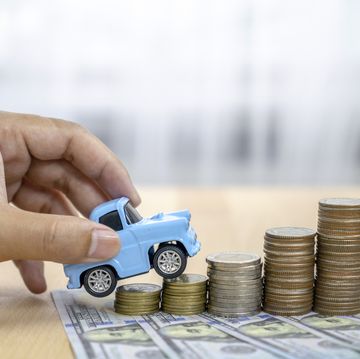businesswoman and toy car on coin stack insurance, loan and buying car concept