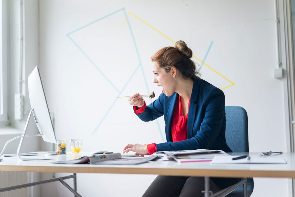 Businesswoman eating lunch in office