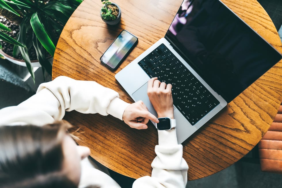 a businesswoman or a freelancer is working at a cafe using gadgets