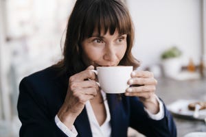 businesswoman sitting in cafe, drinking coffee