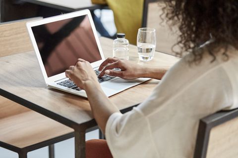 businesswoman using laptop at table in cafe
