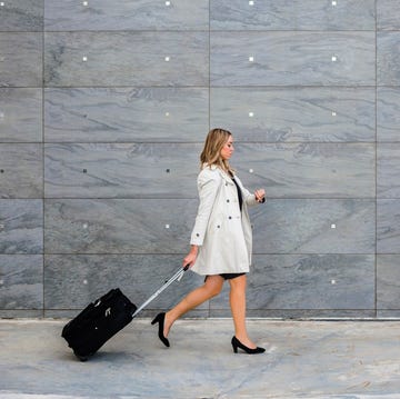Businesswoman with suitcase wearing trench coat businesswoman with suitcase wearing trench coat
