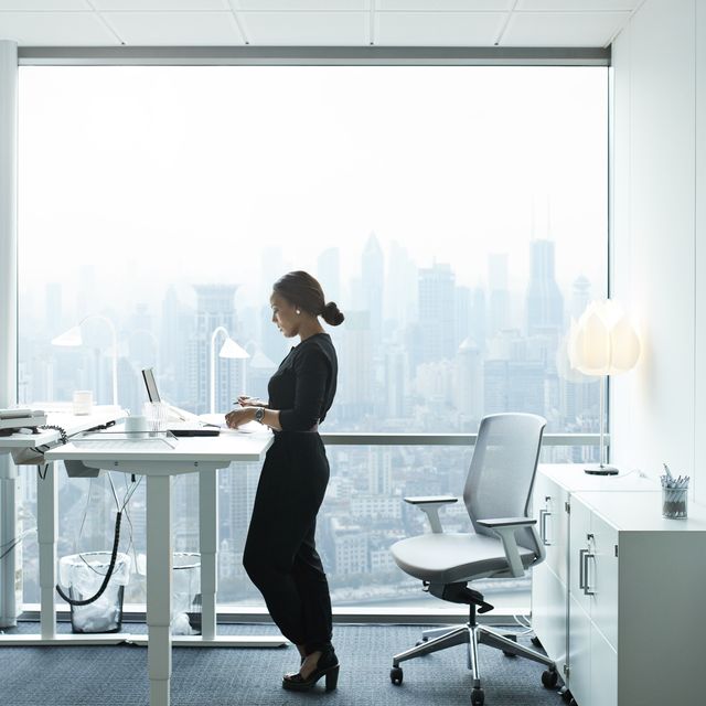 businesswoman working on computer in office with beautiful view of skyline