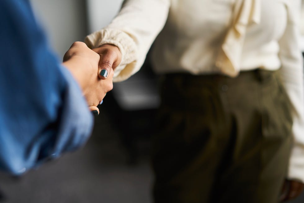 businesswomen shaking hands in conference room