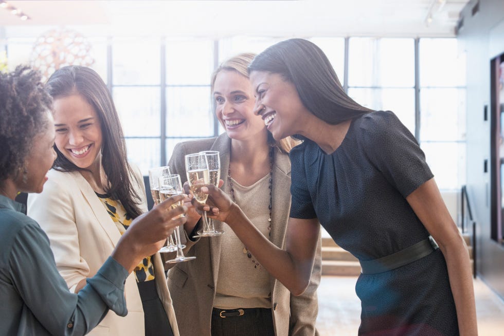 businesswomen toasting with champagne in office