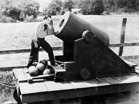 buster keaton standing in front of cannon