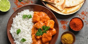 Butter chicken with rice served on grey table, flat lay