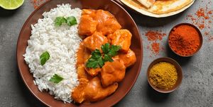 Butter chicken with rice served on grey table, flat lay