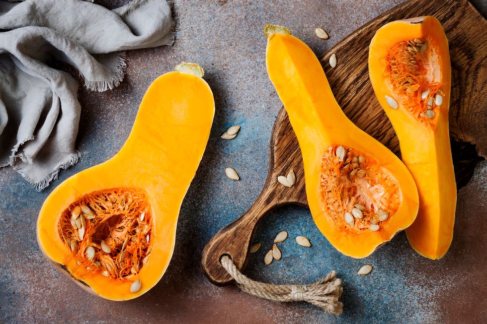 butternut squash on wooden board over rustic background healthy fall cooking concept