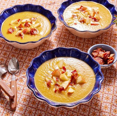 butternut squash soup with apples and bacon in blue bowls