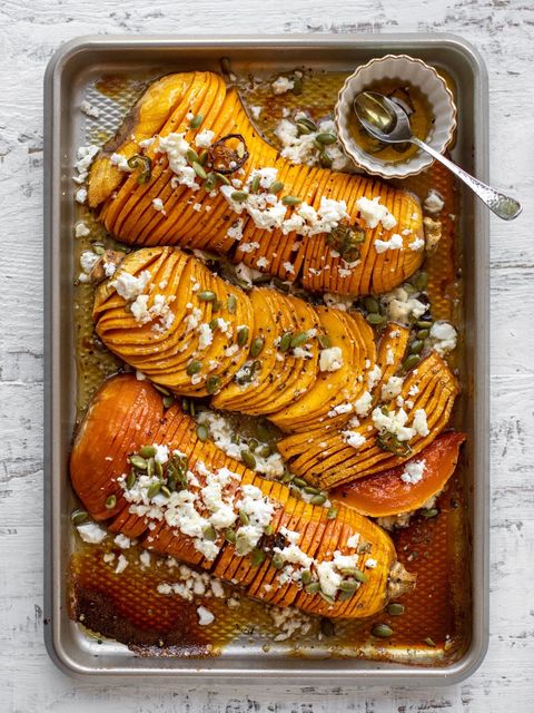 hot honey hasselback butternut squash with feta and pepitas on a sheet tray