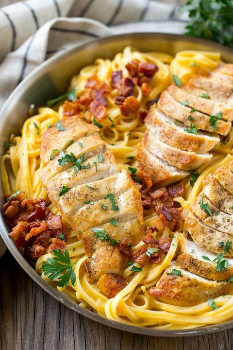 butternut squash pasta with bacon and sliced chicken in a metal skillet