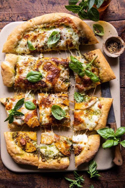 rosemary roasted butternut squash pizza on a pizza stone with fresh basil on top