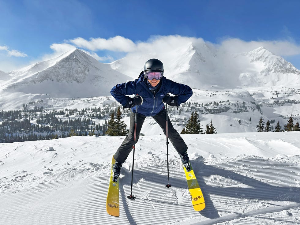 person skiing on a snowy slope with mountains in the background