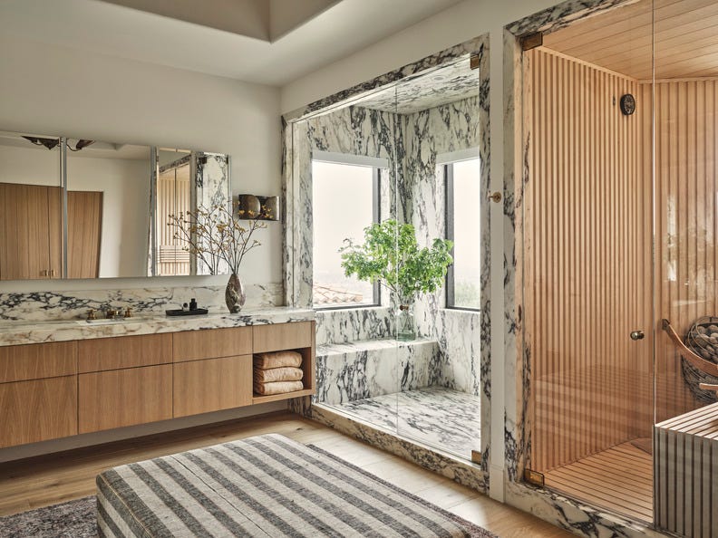 jaqui seerman chose slabs of the same richly veined stone to frame the sauna\, pave the walk in shower\, and serve as a countertop and backsplash