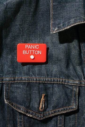 close up of panic button worn on denim jacket anxiety nervous