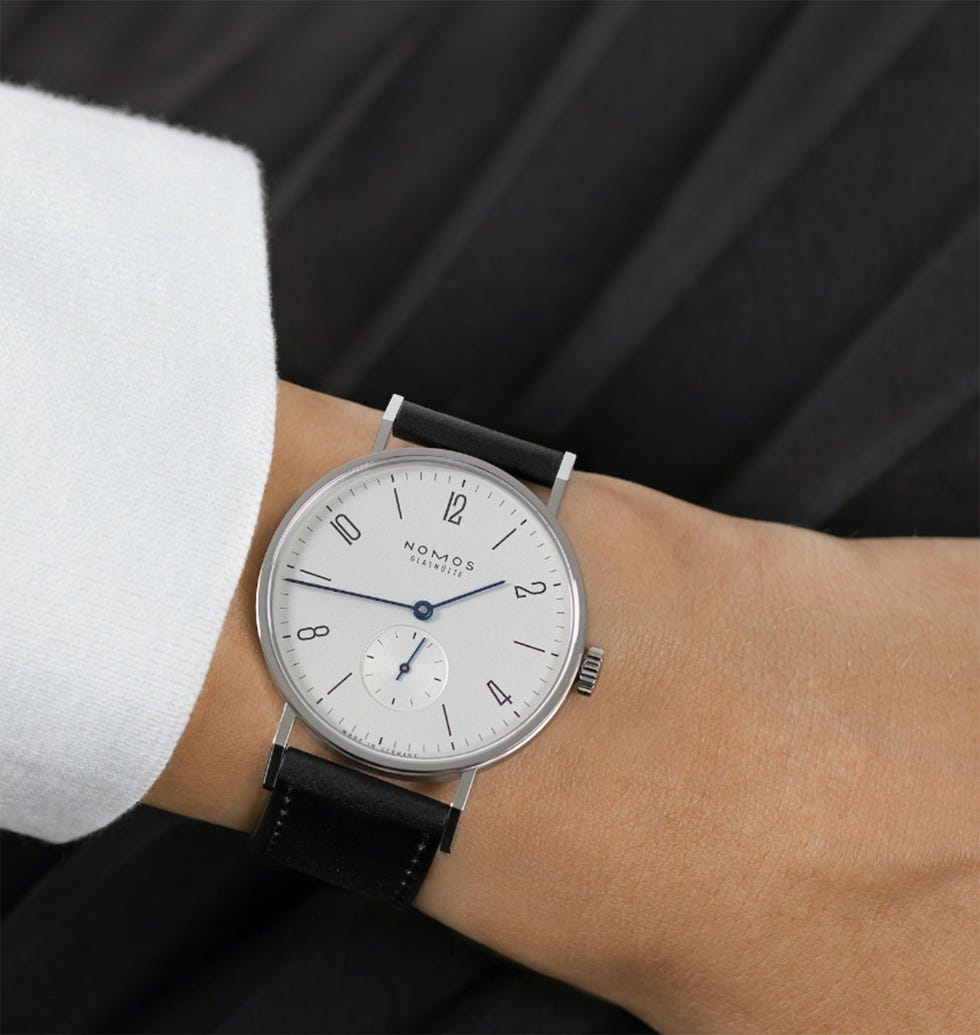 a wristwatch displayed on a hand with a white shirt