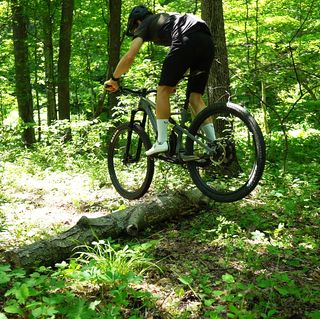 mountain biker bunny hopping a log