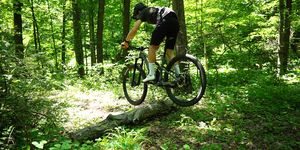 mountain biker bunny hopping a log