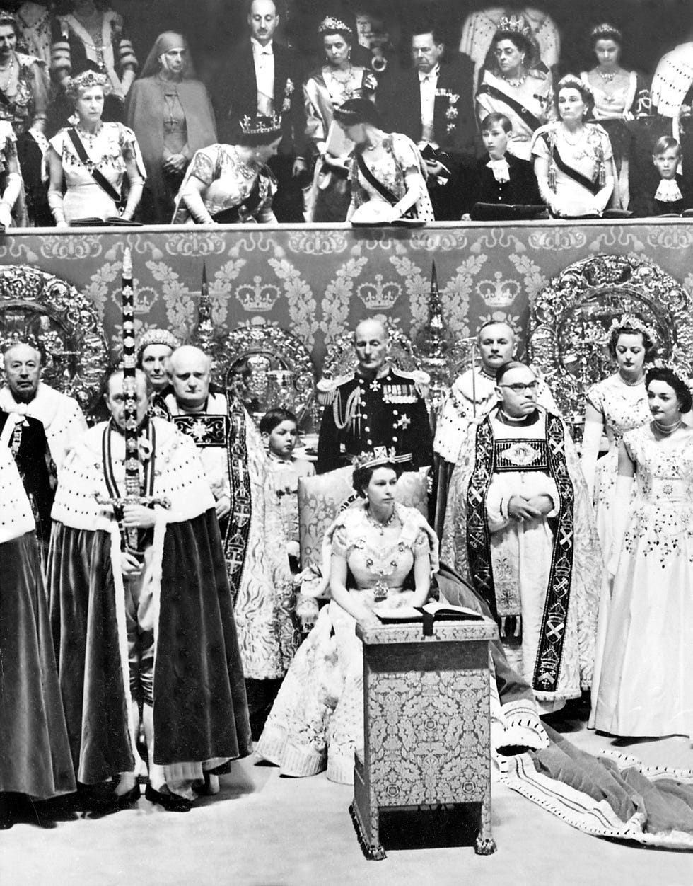 c13gaw queen elizabeth ii, seated in the chair of state in front of royal box where the queen mother left and princess margaret right try to get prince charles to stand for the coronation of his mother, june 2, 1953