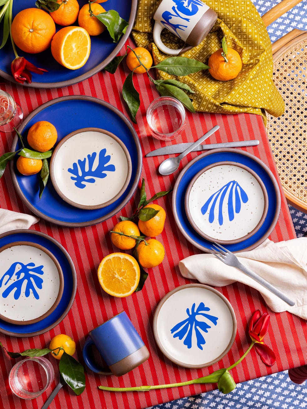 A vibrant dining table setup featuring colorful plates and fresh fruits.