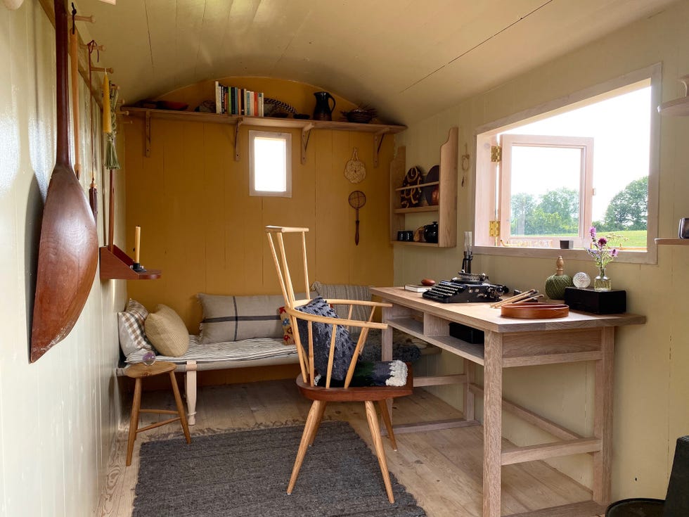 interior de la cabaña con escritorio y sofá cama de estilo rústico