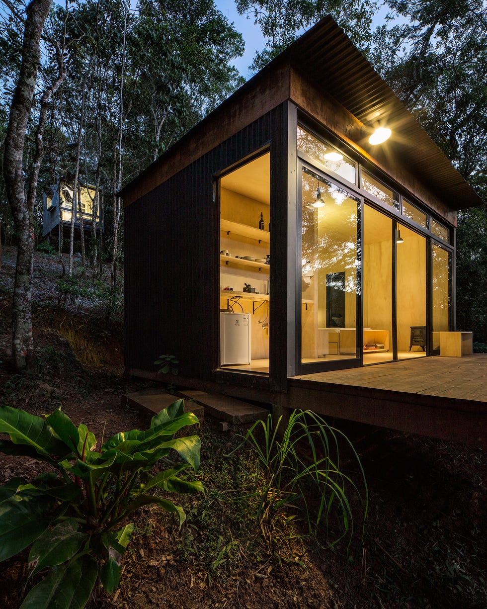 cabaña en el bosque iluminada por noche