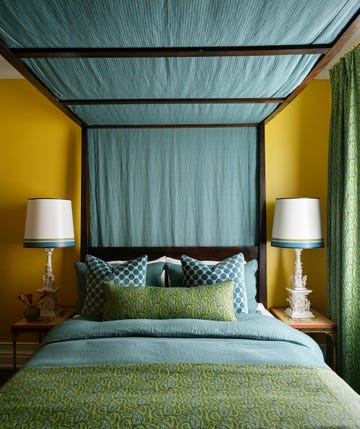 tommy smythe designed guest room with canopied bed dressed in blue and green linens