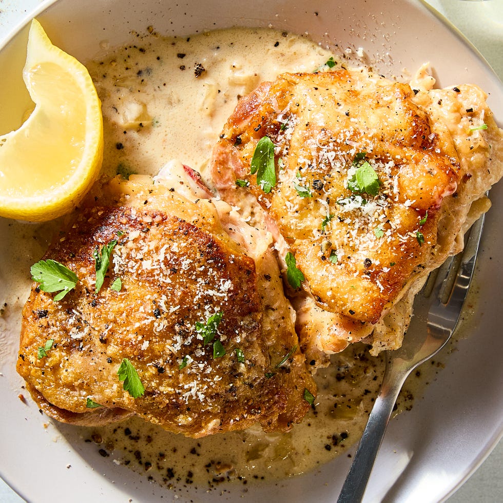 cacio e pepe chicken thighs with lemon wedges