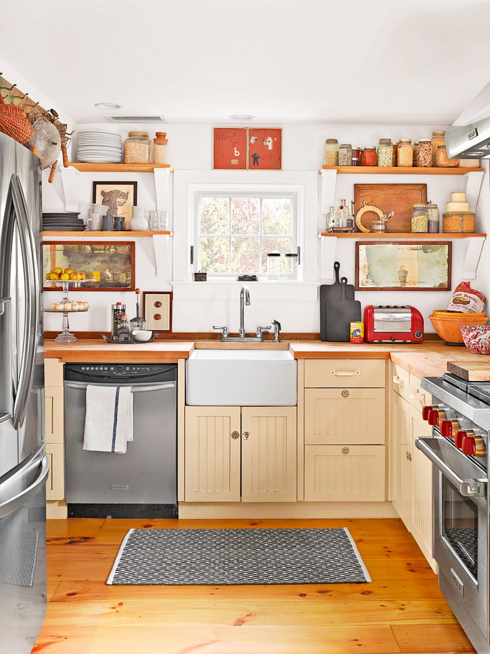 Small kitchen with cream cabinets and wooden shelves