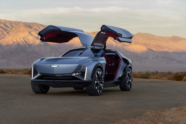 front 3/4 view of the cadillac elevated velocity concept in vapor blue with the gull wing doors open with the desert in the background.