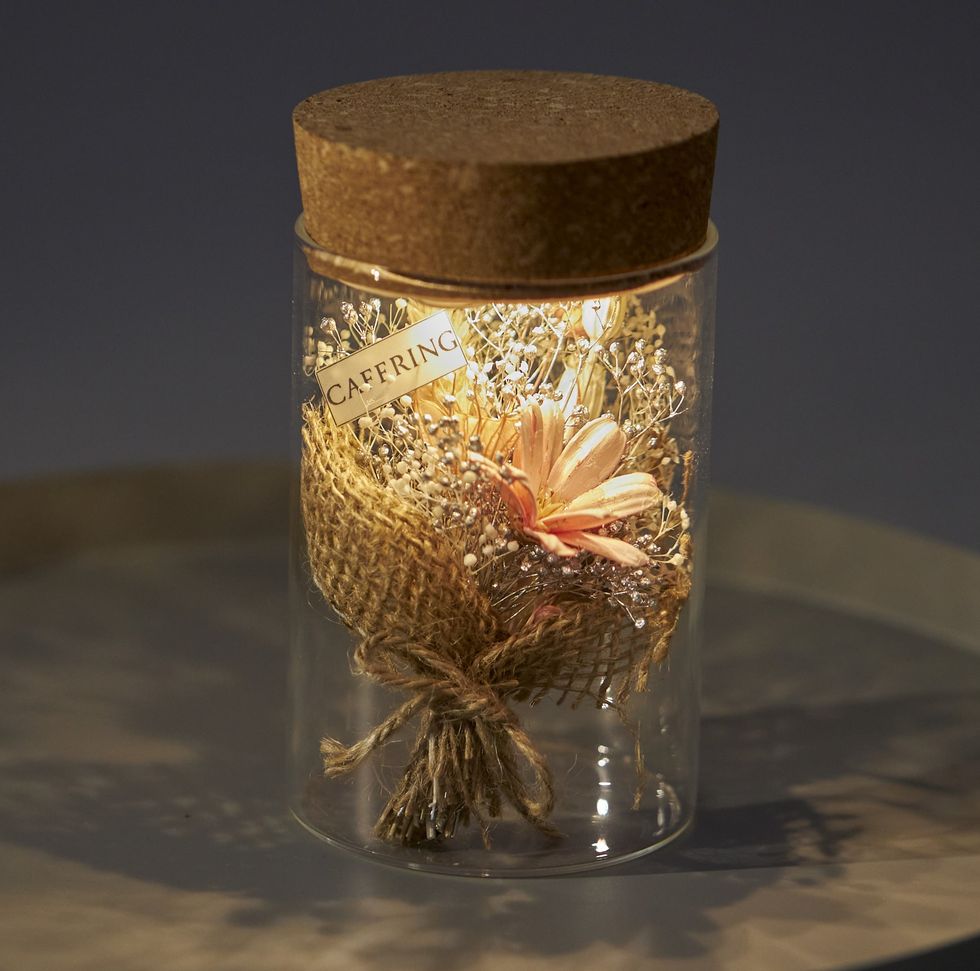 a glass jar with a goldfish inside