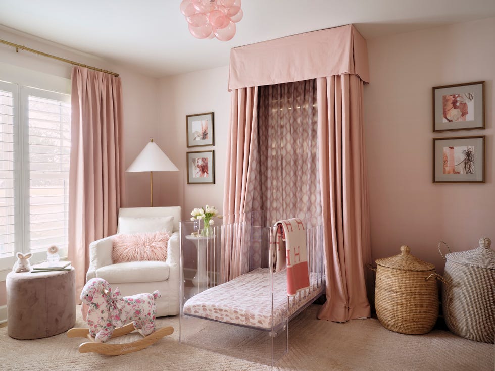 a softly decorated nursery featuring a rocking horse and transparent crib