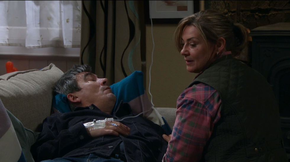 moira dingle sits by cain and turns around to thank john, emmerdale