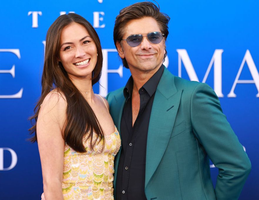 john stamos embracing wife caitlin mchugh for a photo at a film premiere