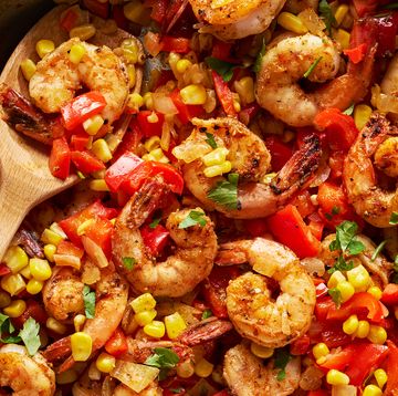 cajun spiced shrimp in a skillet with sliced bell peppers and corn