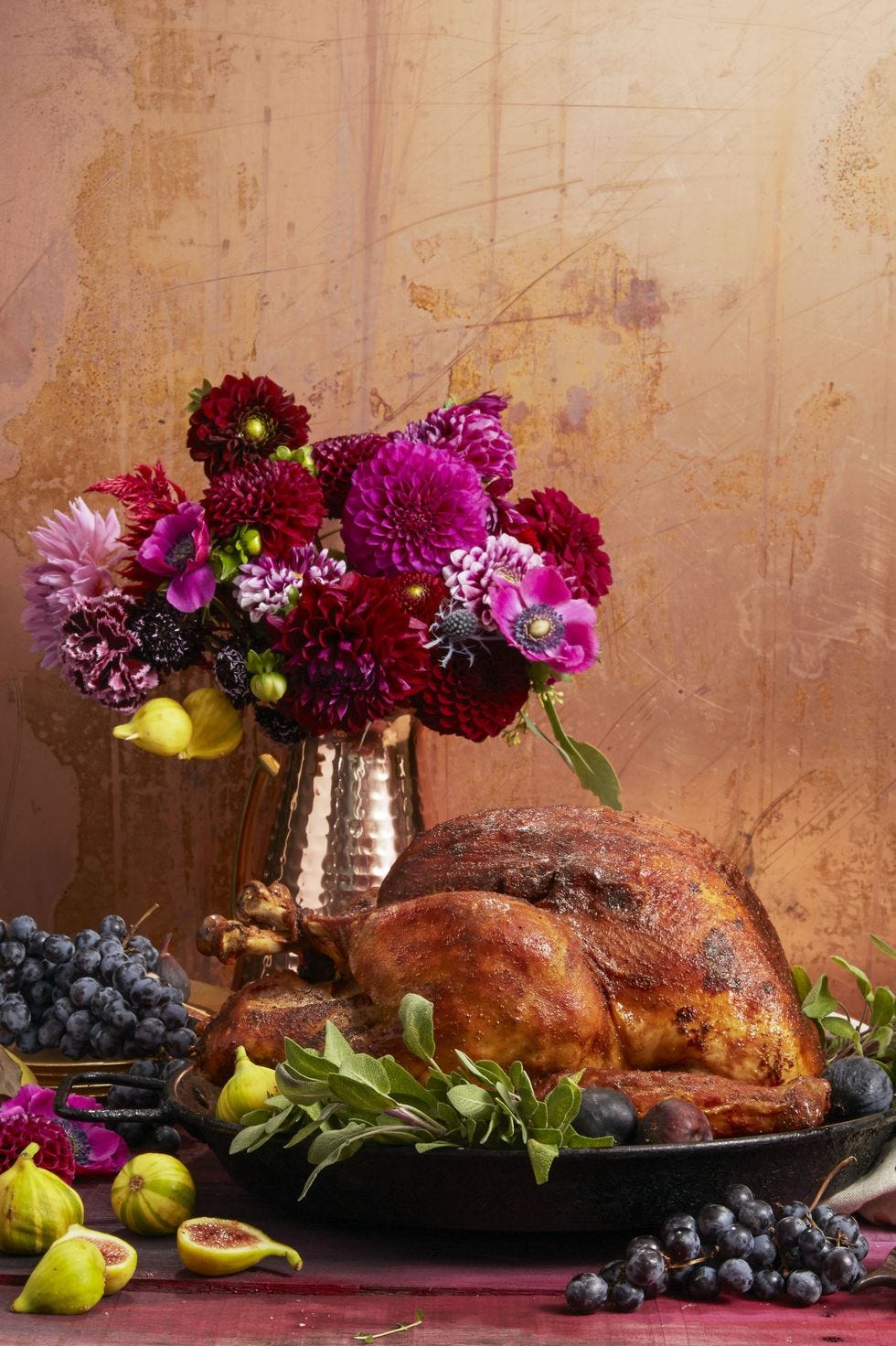 cajun spiced thanksgiving turkey on a platter with a vase of purple flowers in the background