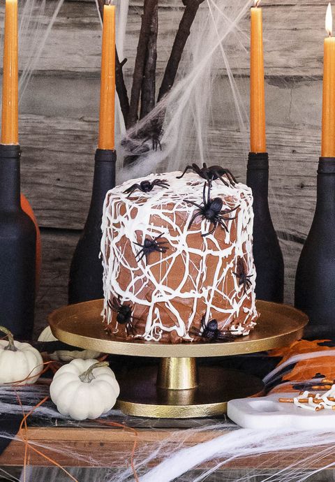 chocolate cake with white chocolate spider web frosting and fake spiders