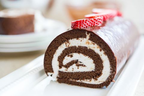 chocolate swiss roll cake with vanilla frosting and strawberries
