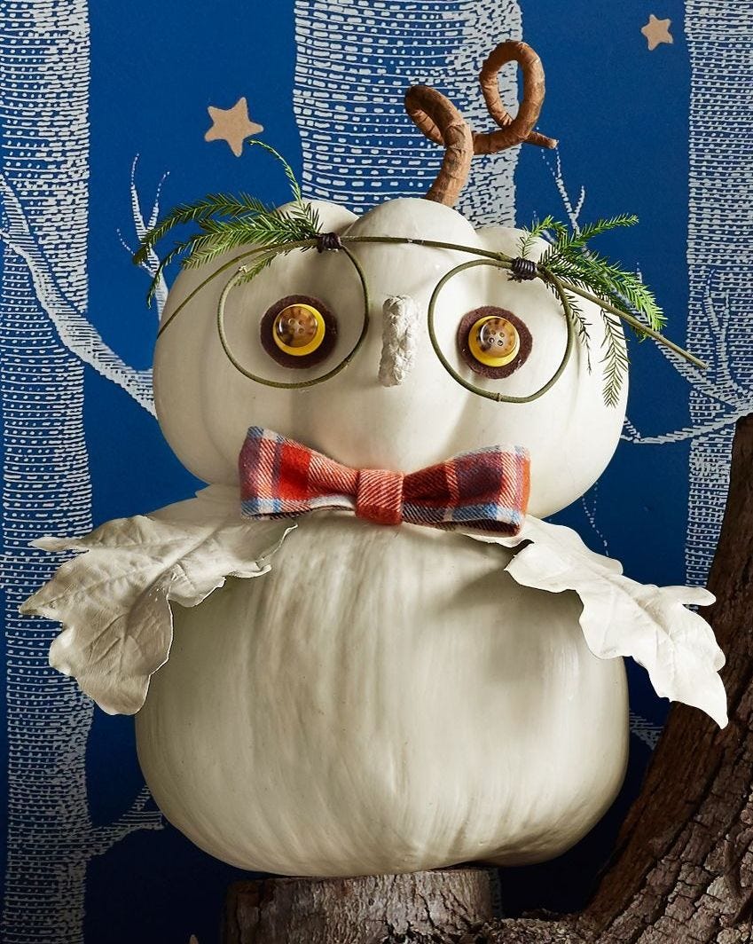 crea un búho de halloween con dos calabazas blancas