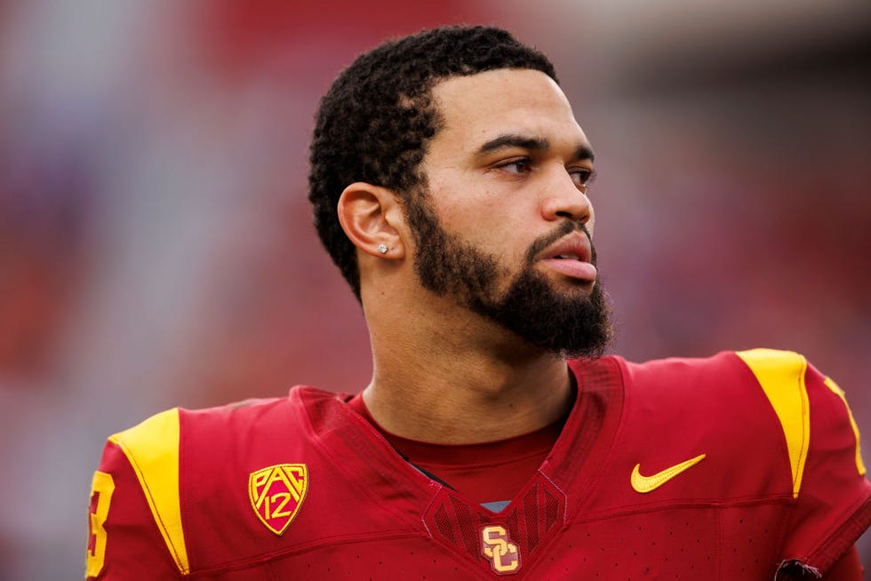 caleb williams looks to the right while wearing a red and yellow university of southern california football jersey