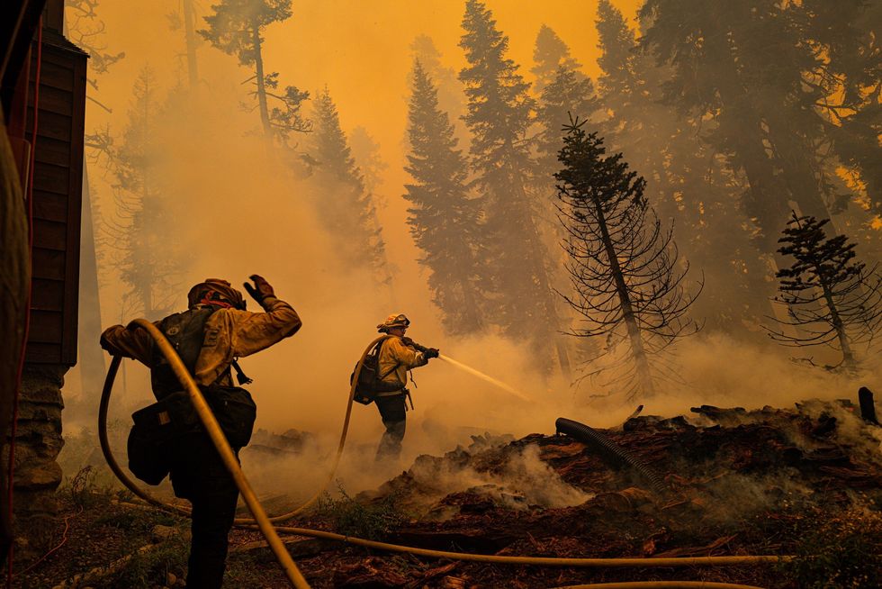 Brandweerlieden uit Santa Clara proberen op 30 augustus gebouwen te beschermen op de Echo Summit een bergachtig gebied ten oosten van Sacramento in Californi Door intense hitte en dor kreupelhout kunnen vaker bosbranden ontstaan die ook groter kunnen worden